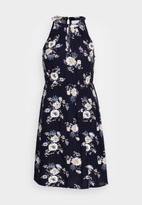 Vestido floral azul marino con escote halter, detalle de abertura y cintura fruncida. Presenta flores beige y azul claro sobre una tela ligera.