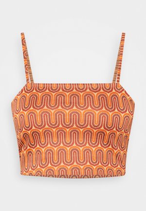 Pestrý zkrácený top s tenkými ramínky, který má vlnitý vzor v oranžové, červené a hnědé barvě na texturované tkanině.