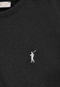 Svart bomulls t-shirt med rund hals som har en liten, vit broderad golfarelogotyp på vänster bröstområde. Mjuk och len textur.
