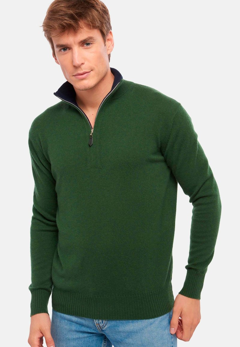 Pull-over en tricot vert avec un col zippé, dotée d'un col intérieur bleu marine, de poignets côtelés et d'une coupe slim.