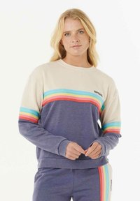 Sweatshirt mit der oberen Hälfte in Creme und der unteren Hälfte in Marineblau, verziert mit horizontalen Regenbogenstreifen und einem gerippten Halsausschnitt.