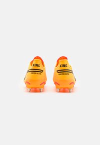 Bright orange football cleats with metal studs, black "KING" text, and "FOREVER.FASTER." slogan on the heel, shown from the back.