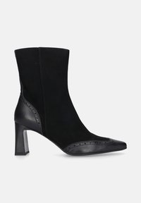 Zwarte enkellaars van suede en leer, met een puntige neus, een gestapeld hak en brogue-details langs de naad.