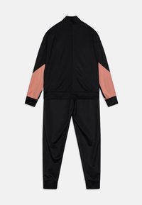 Chándal negro que incluye una chaqueta con cremallera y paneles de acento rosa en las mangas, junto con pantalones a juego. Textura suave y puños elásticos.