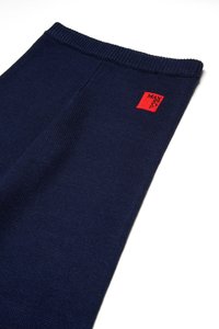 Mørkeblå ribbestrikkede bukser med et rødt kvadratisk merke som har "MAX"-teksten brodert i svart. Elastisk midje, strukturert design.