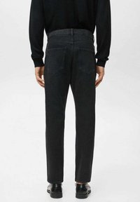 Vaqueros negros de mezclilla con corte recto, diseño de cinco bolsillos, costuras visibles y cintura con cinturilla. La parte trasera tiene dos bolsillos parche.