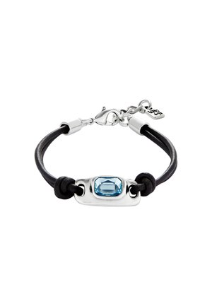 Bracelet en cuir noir avec une pièce centrale rectangulaire en métal argenté ornée d'une pierre précieuse bleue, maintenu par des nœuds et un fermoir à ressort.