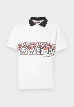 Λευκό πόλο μπλουζάκι με κοντά μανίκια, μαύρο γιακά, σειρά κουμπιών και οριζόντια σειρά από πλαίσια με καρτούν λουλούδια σε κόκκινο και άσπρο στο στήθος.