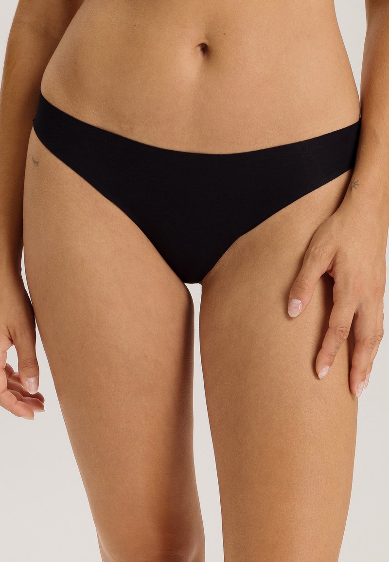 Bas de bikini en coton noir avec une taille basse, une couverture minimale et une texture lisse. Présente un design simple sans embellissements.