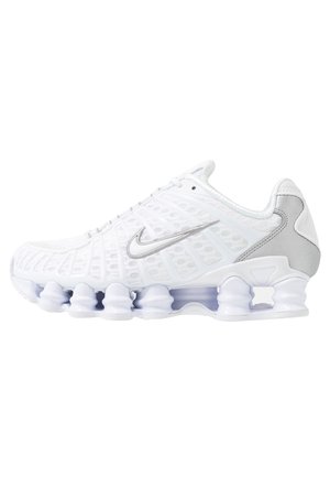 Chaussure de sport Nike blanche avec tige en mesh, swoosh argenté et semelle segmentée distincte en forme de ressort pour un meilleur amorti, vue de profil.