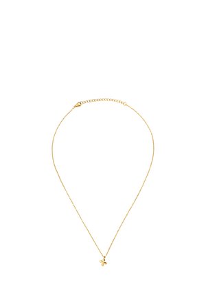 Collier délicat en chaîne d'or avec un petit pendentif croix et un fermoir ajustable sur fond blanc.