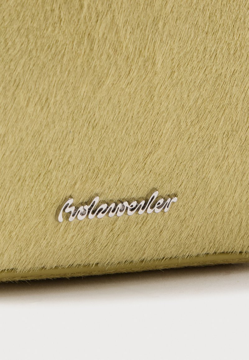 Zacht gestructureerd lichtgeel oppervlak met een klein zilverkleurig metalen logo met de tekst "Rosenweller" vlakbij de onderrand.