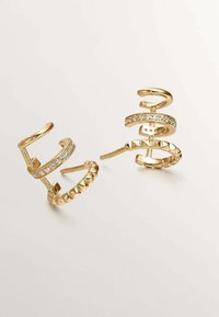 Pendientes en tono dorado con un diseño en espiral, adornados con cristales transparentes y acentos texturizados. Ligeros, de estilo moderno y apariencia elegante.