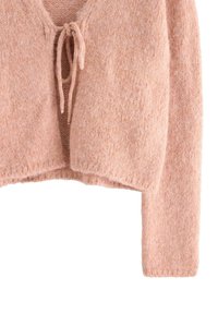 Mjuk rosa stickad cardigan med långa ärmar och frontknäppning, i strukturerad ullblandad tyg, visad på vit bakgrund.