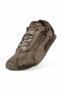 Καφέ αθλητικό παπούτσι Puma με υφή σουέντ, κορδόνι εμπρός και υφασμένο καουτσούκ σόλα σε γωνία, που δείχνει λεπτομέρειες από το πλάι και από πάνω.