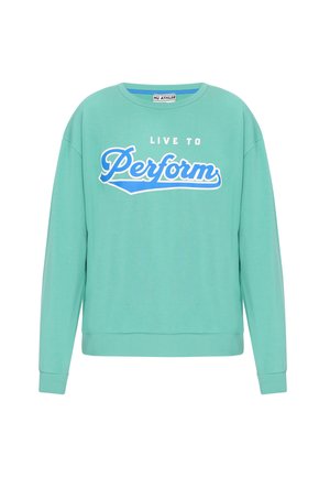 Mēteņzaļš džemperis ar apaļu kakla izgriezumu, garām piedurknēm, elastīgām aprocēm un apakšmalu. Uzraksts "DZĪVO, LAI IZPILDĪTU" baltā un zilā krāsā.