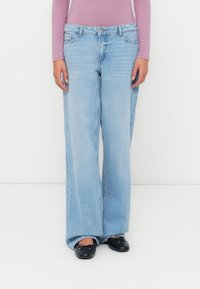 Világoskék, laza szabású farmernadrág, egyenes lábfej kialakítással, gombos záródással és klasszikus ötk zsebes stílussal. Simító denim textúra.
