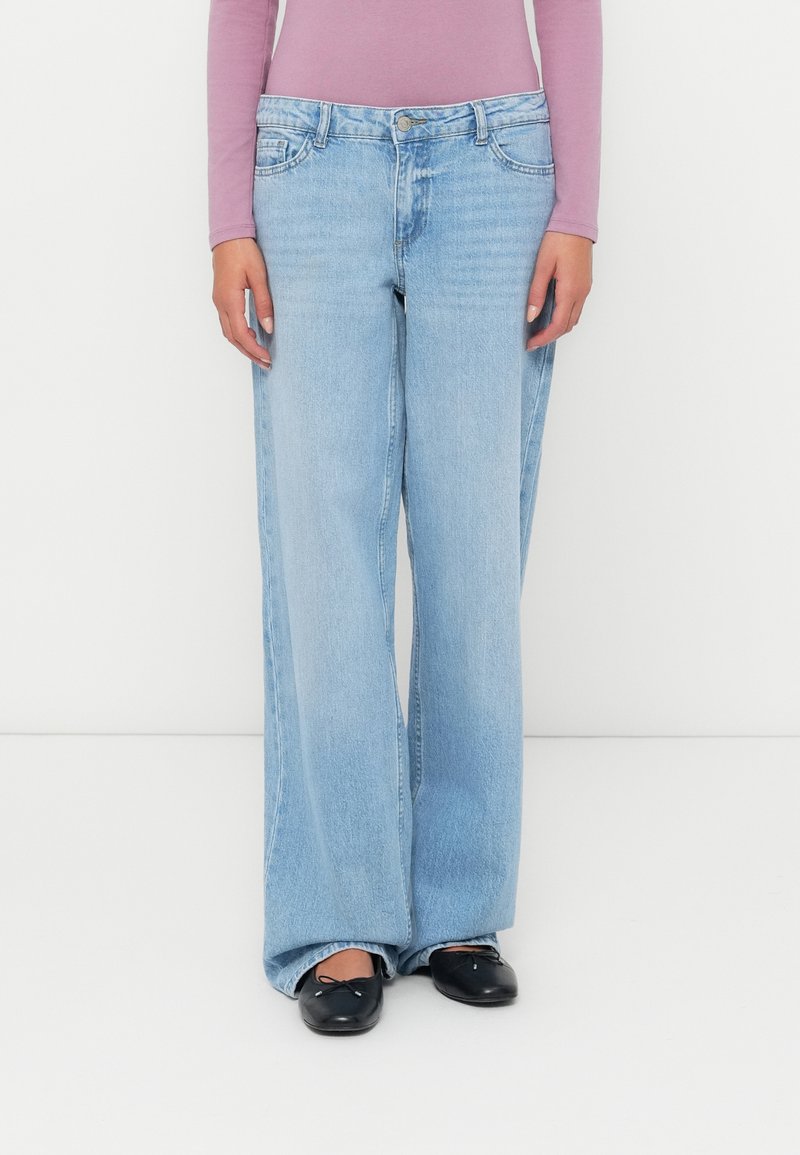 Világoskék, laza szabású farmernadrág, egyenes lábfej kialakítással, gombos záródással és klasszikus ötk zsebes stílussal. Simító denim textúra.