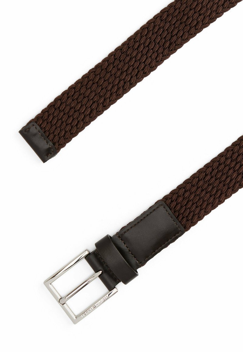Ceinture en textile brun tressé avec une extrémité en cuir marron foncé lisse et une boucle en métal argenté de forme rectangulaire.