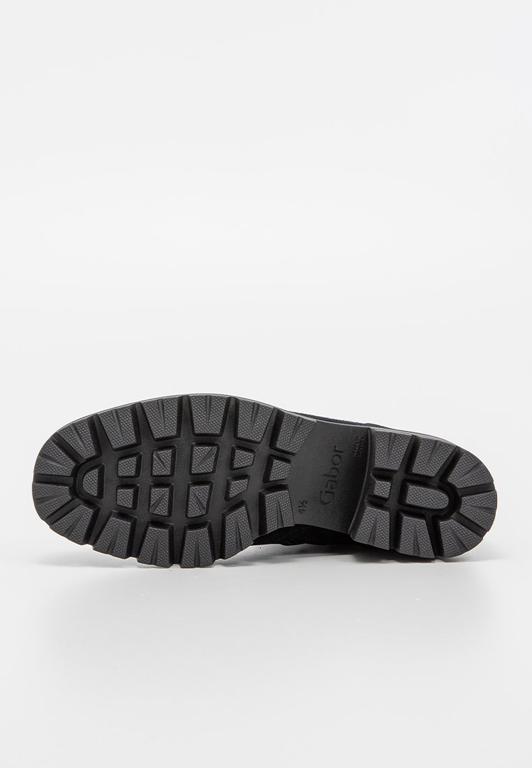 Suola di scarpa in gomma nera con un motivo di battistrada testurizzato, caratterizzato da scanalature profonde per la presa e il marchio "Gabor" visibile sulla base.