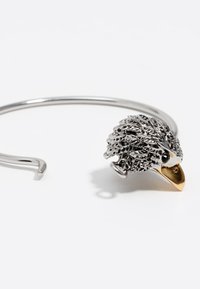 Pulsera de alambre de plata con una cabeza de erizo detallada en plata y oro, con pelaje texturizado y un pico brillante.