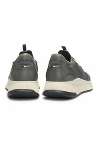 Scarpe sportive grigie con una combinazione di pelle liscia e tessuto testurizzato, dotate di un intersuola bianca, suola nera e sottili accenti di colore.
