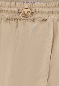 Costumi da bagno beige con vita elasticizzata e cordoncino con bottone. Tessuto liscio e design a taglio dritto con dettagli di cucitura.
