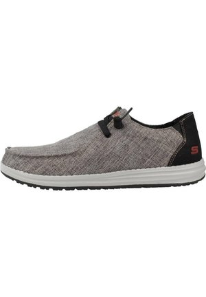 Scarpa slip-on in tessuto grigio con punta arrotondata, dettagli neri e suola in gomma bianca. Presenta lacci elastici per una facile calzata.