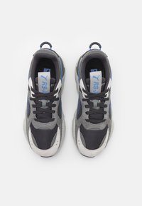 Zapatillas que combinan malla en tonos gris, negro y azul con detalles en ante, puntera redonda y cordones planos. Suelas texturizadas con una lengüeta de tirador en forma de lazo.