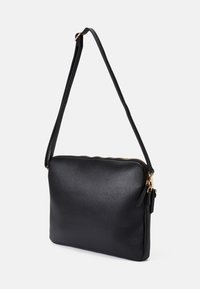 Schwarze Umhängetasche aus Kunstleder mit glatter Oberfläche, Reißverschluss und abnehmbarem Gurt; mit Akzenten aus goldfarbenem Metall.