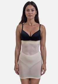 Shapewear beige senza cuciture con vita alta, caratterizzato da una texture liscia e bordi elastici, abbinato a un reggiseno imbottito nero.