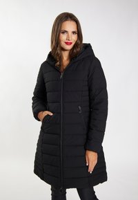 Cappotto imbottito nero con cappuccio, caratterizzato da pannelli trapuntati, due tasche laterali con zip e una zip Frontale completa. Tessuto liscio e strutturato.