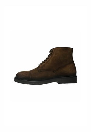 Bottes en suède marron à la cheville avec un bout arrondi, un design à lacets et une semelle en caoutchouc texturé. Présente des détails de couture le long des coutures.