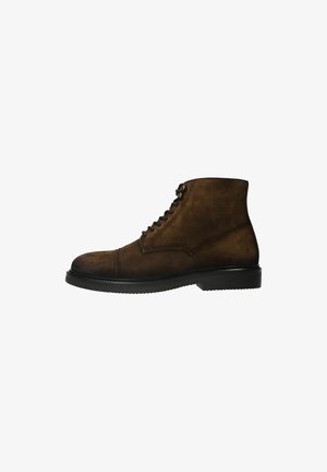 Bottes en suède marron à la cheville avec un bout arrondi, un design à lacets et une semelle en caoutchouc texturé. Présente des détails de couture le long des coutures.
