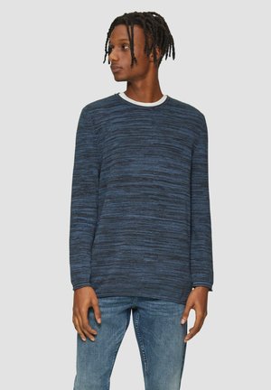 Navyblauwe trui in een gestructureerde brei met lange mouwen en een ronde hals. Draagt met lichtblauwe jeans.