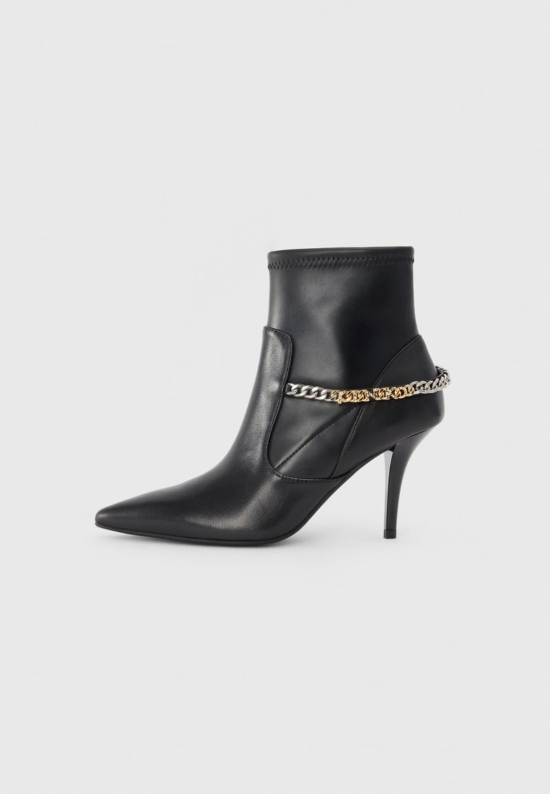 Bottine noire en cuir avec un talon aiguille haut, un bout pointu et une chaîne décorative en or et argent autour de la cheville.