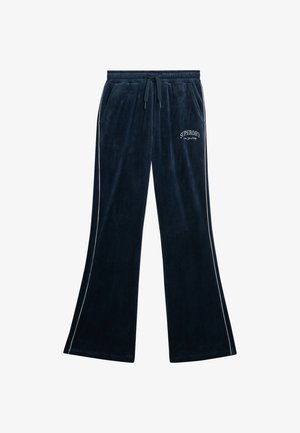 Pantaloni tuta in velluto blu navy con vita regolabile, tasche laterali e rifiniture bianche; presenta la scritta "SUPERDRY" ricamata sul davanti.