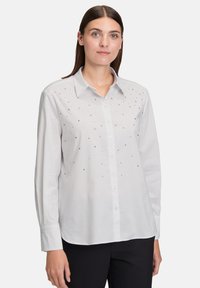 Witte button-up shirt met lange mouwen, voorzien van decoratieve rhinestones op de voorkant. Klassiek kraagontwerp en aansluitende silhouet.