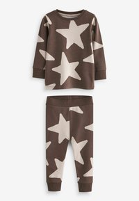 Ensemble marron composé d’un haut à manches longues et d’un pantalon avec de grands motifs étoiles blanches, poignets côtelés aux manches, à la taille et aux jambes du pantalon.