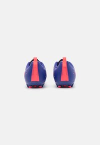 Scarpe da football blu con accenti rosa. Presentano una tomaia testurizzata, una linguetta sul tallone di contrasto e una suola in TPU con tacchetti visibili.