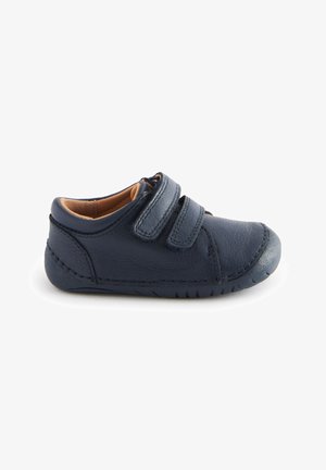 Navy blue toddler shoe made of soft leather, featuring two adjustable Velcro straps and a rounded toe, with textured side stitching.