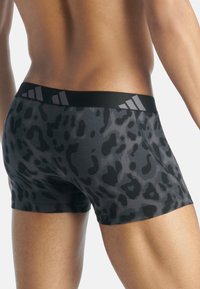 Boxerské trenýrky s leopardím potiskem v černé barvě, s širokým černým pasem s šedými pruhy; vyrobené z lehké, elastické tkaniny.