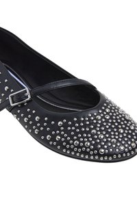Ballerines en cuir noir avec un bout arrondi, ornées de clous décoratifs en argent, et une fine bride à la cheville avec une boucle en métal.