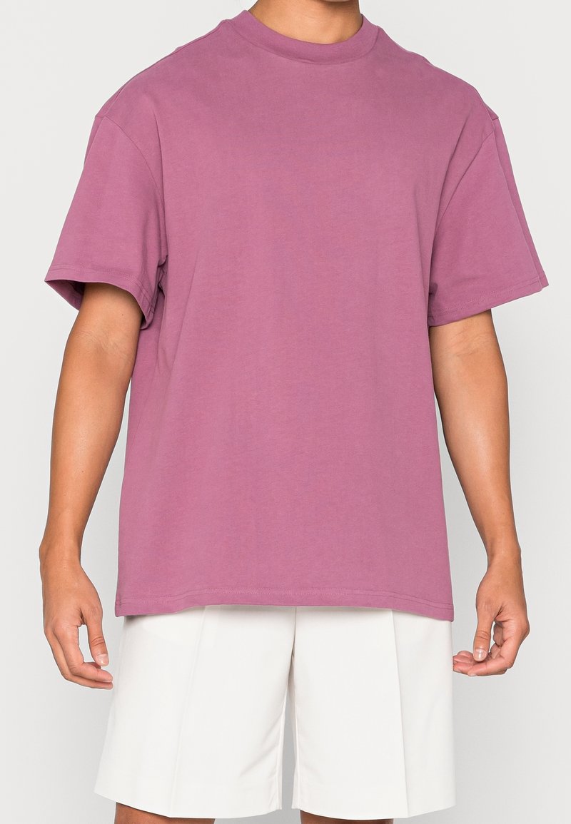 T-shirt à col rond à manches courtes en coton violet doux et léger, doté d'une coupe décontractée et d'une couleur unie sans graphiques ni motifs.