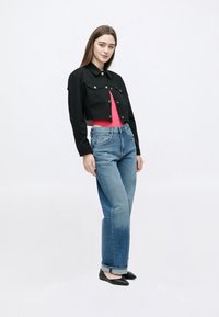 Mustast kropsest teksatakist, roosa topi, siniste teksade ja mustade plätudega; esiküljel nupud, taskud ja kergelt tuhmunud teksariie.