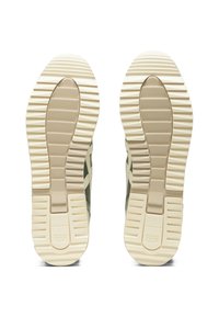 Green sneakers with textured rubber soles, featuring horizontal and vertical grooves, and a beige midsole for cushioning.