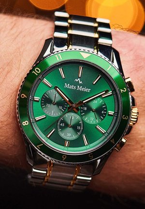 Montre chronographe à cadran vert avec accents en acier et en or, trois sous-cadrans et une lunette marquée. Équipée d'un bracelet en acier inoxydable.