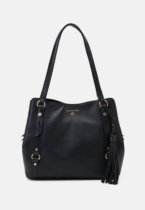 Sac cabas Michael Kors en cuir grainé noir avec longues anses, logo doré, anneaux et un gland décoratif en cuir sur le côté.