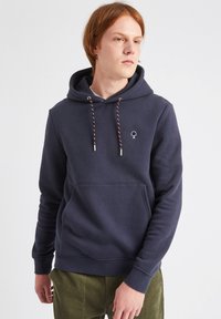 Sudadera azul marino hecha de tela suave, con un bolsillo tipo canguro, cordones ajustables con acentos rojos y blancos, y un pequeño logo en el pecho.
