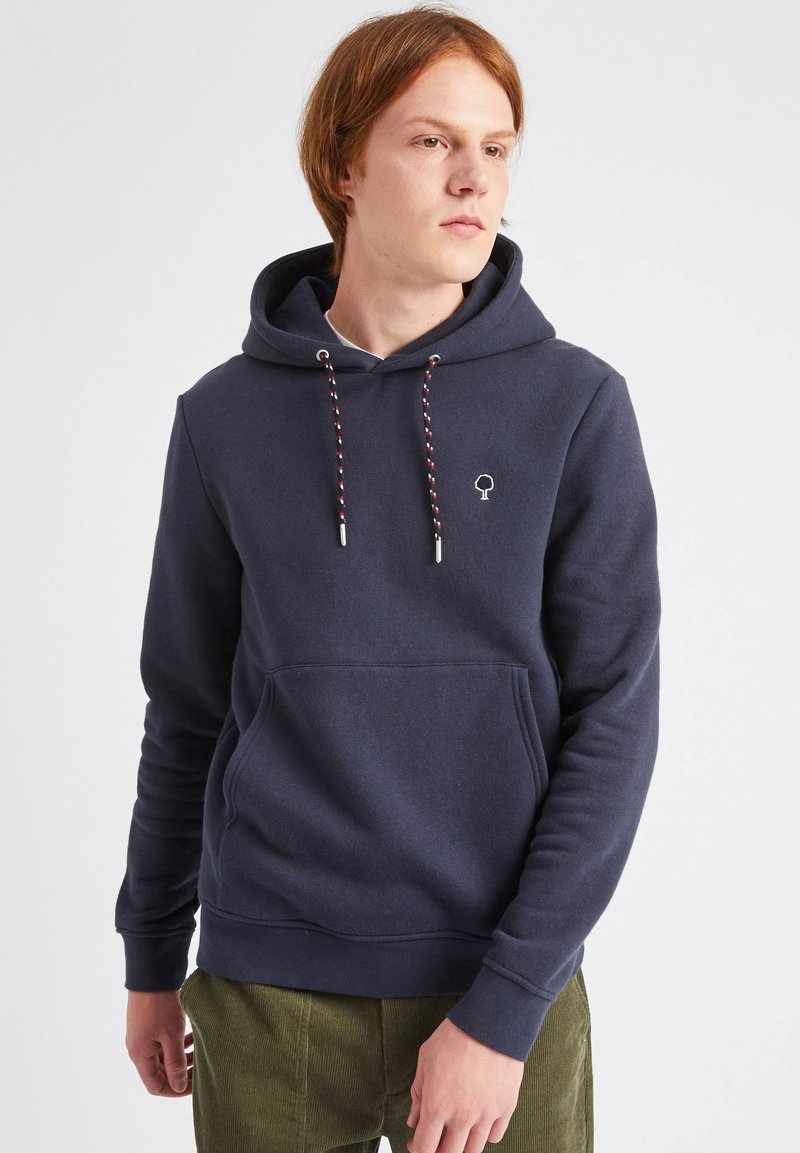 Sudadera azul marino hecha de tela suave, con un bolsillo tipo canguro, cordones ajustables con acentos rojos y blancos, y un pequeño logo en el pecho.